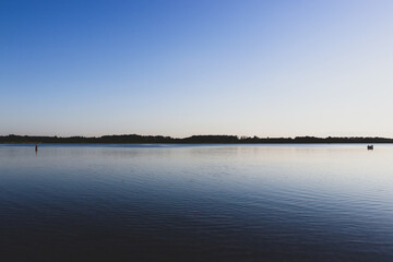 one person stands far from a group of people in the lake. interpersonal relationships cocept.