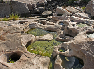 Geology. Stone valley. View of the natural pond and rocky cliffs in the mountains. 