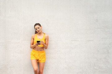 Fitness woman outdoors using mobile phone