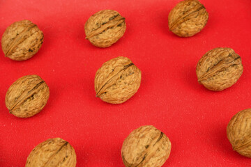 Arrangement of a group of organic walnuts on a red background
