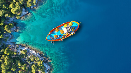 Aerial drone top down photo of traditional fishing boat anchored near small picturesque port of Agnontas, Skopelos, Sporades, Greece © aerial-drone