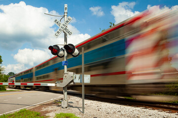 Fast moving Train Engine and passenger cars at an intersection