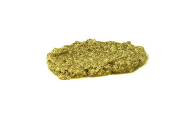 Pesto spread or blob in a bowl isolated on white background. Green italian homemade spilled sauce made of ground basil, garlic, pine seeds, olives and pecorino sardo cheese 
