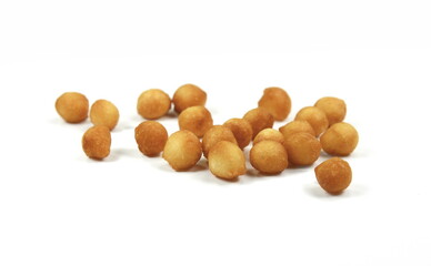 Fried batter pearls in a clay bowl. Crispy pearls. A soup topping and snack product made from flour, vegetable fat and yeast. Isolated macro food photo close up from above on white background.