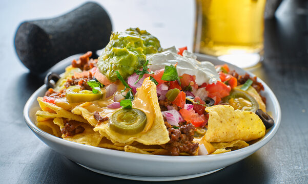 plate of loaded nachos with queso cheese