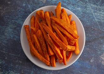 Plate of Sweet Potatoe Fries on a Blue Wooden Table