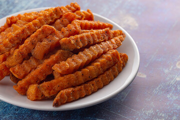 Plate of Sweet Potatoe Fries on a Blue Wooden Table
