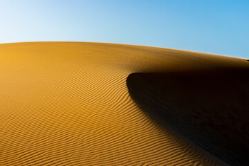 Golden sand dunes at sunset, with a side of shadow in Corralejo, Fuerteventura