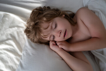 Obraz na płótnie Canvas Kids little boy sleeps in the bed on white pillow.