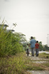 Asian family walking with bicycle. Outdoor togetherness.