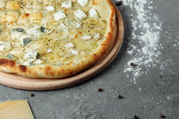 four cheese pizza, italian pizza. pizza stuffed with four varieties of cheese on a gray background.