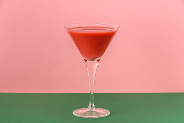 Strawberry smoothie cup on a pink and green background