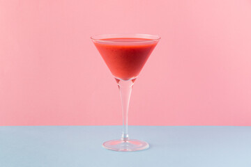 Strawberry smoothie cup on a pink and light blue background