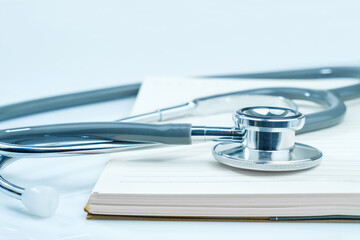 Medical stethoscope for doctor checkup and notepad on table