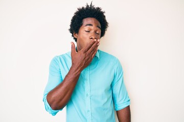 Fototapeta na wymiar Handsome african american man with afro hair wearing casual clothes bored yawning tired covering mouth with hand. restless and sleepiness.