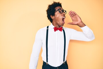 Handsome african american man with afro hair wearing hipster elegant look shouting and screaming loud to side with hand on mouth. communication concept.