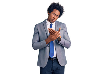 Handsome african american man with afro hair wearing business jacket suffering pain on hands and...