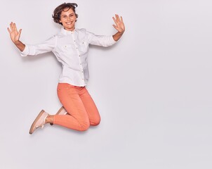 Young beautiful woman wearing casual clothes smiling happy. Jumping with smile on face and arms opened over isolated white background.