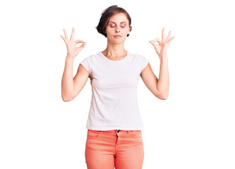 Fototapeta na wymiar Beautiful young woman with short hair wearing casual clothes relax and smiling with eyes closed doing meditation gesture with fingers. yoga concept.