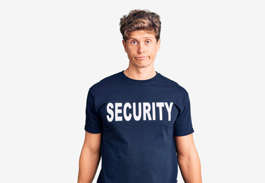 Young handsome man wearing security t shirt depressed and worry for distress, crying angry and afraid. sad expression.