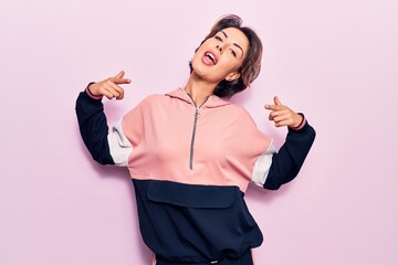 Young beautiful woman wearing sportswear looking confident with smile on face, pointing oneself...
