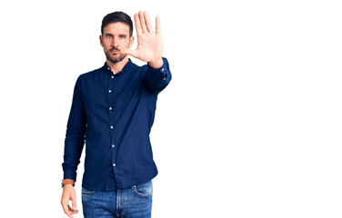 Young handsome man wearing casual shirt doing stop sing with palm of the hand. warning expression with negative and serious gesture on the face.