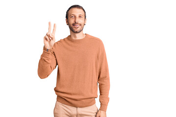 Naklejka premium Young handsome man wearing casual clothes showing and pointing up with fingers number two while smiling confident and happy.