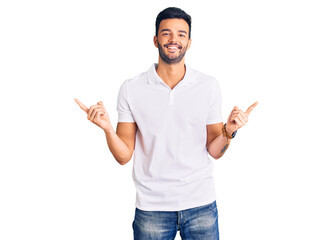 Fototapeta premium Young handsome hispanic man wearing casual clothes smiling confident pointing with fingers to different directions. copy space for advertisement