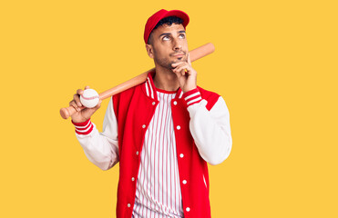 Young hispanic man playing baseball holding bat and ball serious face thinking about question with...