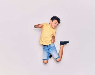 Adorable kid wearing casual clothes jumping over isolated white background