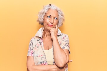 Senior grey-haired woman wearing casual clothes serious face thinking about question with hand on chin, thoughtful about confusing idea