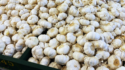 White garlic bulbs.  A large quantity scattered on a table at a market