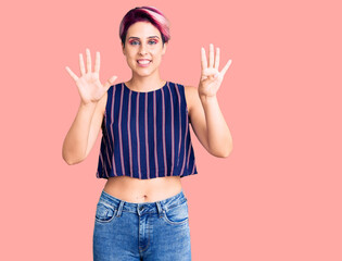 Young beautiful woman with pink hair wearing casual clothes showing and pointing up with fingers number nine while smiling confident and happy.