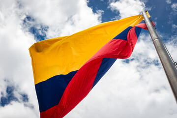 Colombia flag waving in a blue cloudy sky