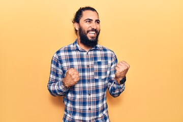 Young arab man wearing casual clothes celebrating surprised and amazed for success with arms raised and eyes closed