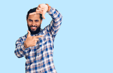 Young arab man wearing casual clothes smiling making frame with hands and fingers with happy face. creativity and photography concept.