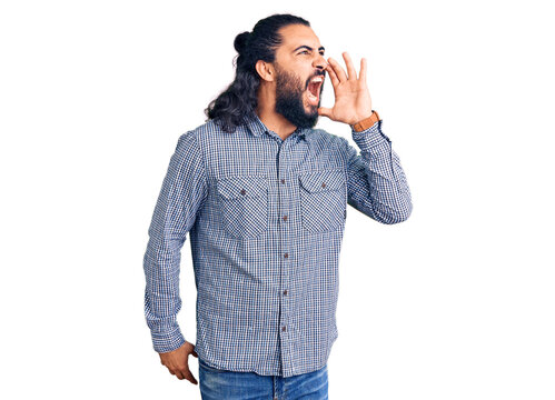 Young arab man wearing casual clothes shouting and screaming loud to side with hand on mouth. communication concept.