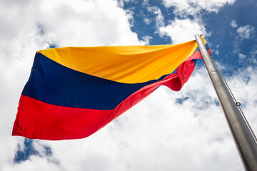 Colombia flag waving in a blue cloudy sky