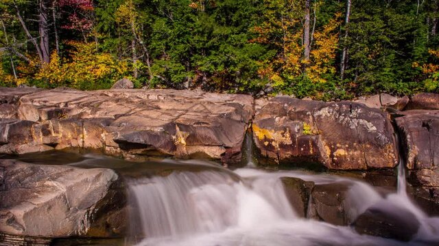 Kancamagus highway in autumn waterfall with colored fall foliage and streaming river off of river rocks Full HD Time Lapse