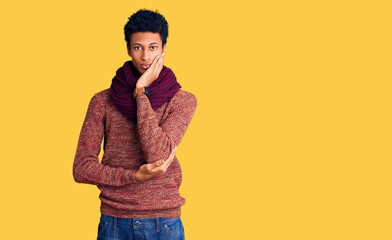 Young african american man wearing casual winter sweater and scarf thinking looking tired and bored with depression problems with crossed arms.