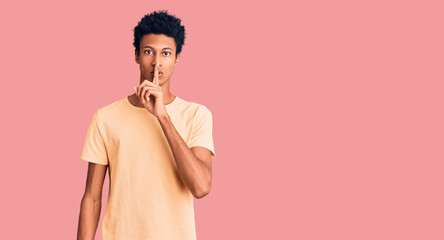 Young african american man wearing casual clothes asking to be quiet with finger on lips. silence and secret concept.