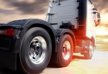 Naklejka na ściany i meble Speeding motion of semi truck on road at sunset sky. Road freight transportation.