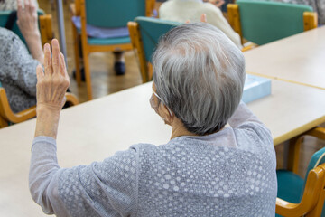 介護施設で指先の体操をする老人