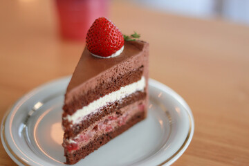 Focus point selection Layer chocolate cake with cream in a white glass dish.