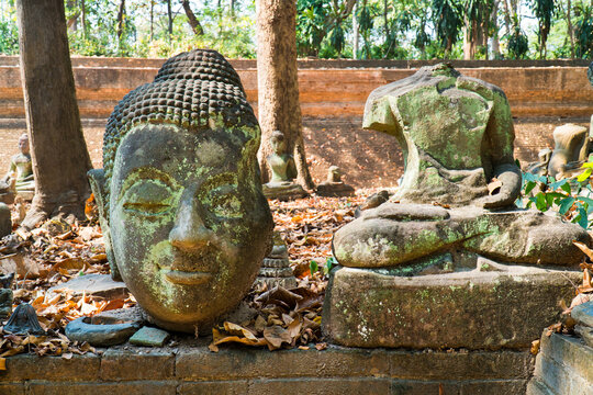 Buddha image statue damaged in temple outdoor background. Buddha image ruined with head and body in wat or temple, Thailand