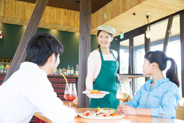 料理を運ぶカフェ店員