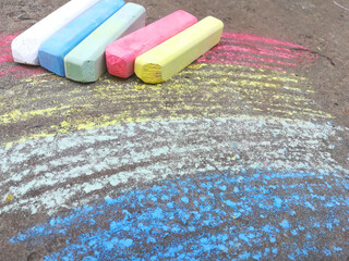 rainbow is drawn with chalk on the asphalt. colored summer background. children drawing, lgbt symbol