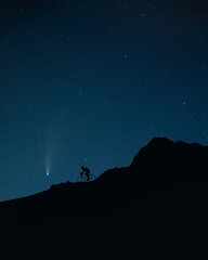 Fototapeta na wymiar Comet Neowise and man riding the bicycle at night