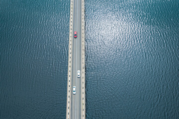 cars crossing road bridge over Vileyka lake in Belarus. aerial top view