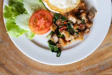 Rice topped with stir-fried pork and basil with On a plate and fried egg